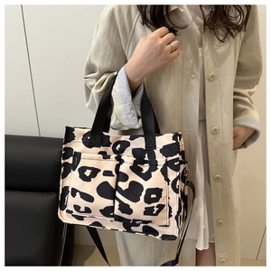 Gros plan du sac cabas en toile à motif léopard avec doubles poches et bandoulière