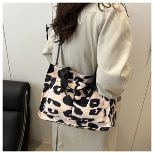Détails du sac cabas en toile léopard avec poches avant et poignées en sangle noires