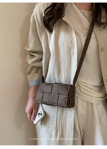 Macro detail of brown woven texture and monogram pattern on small square shoulder bag