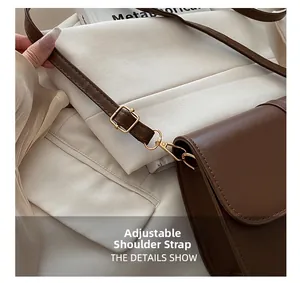 Adjustable brown leather shoulder strap with a refined golden metal buckle detail