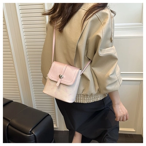 Detail of pink heart-shaped buckle and cartoon print on luxury small square crossbody bag