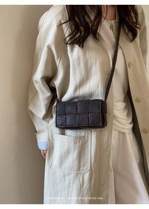 Detail of dark brown woven crossbody bag with textured patterns and retro aesthetic
