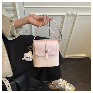 Detailed view of pink flap shoulder bag with silver heart lock and cute plush charm