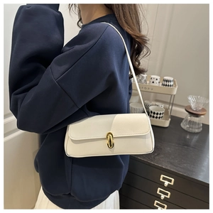 Close-up of white pebble grain underarm bag featuring a gold oval metal buckle