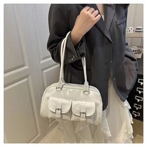 Detail view of white patent leather underarm bag with retro twin front buckle pockets