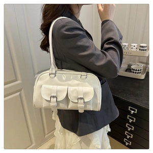 White patent leather Boston bag featuring dual front buckle pockets and slim shoulder strap