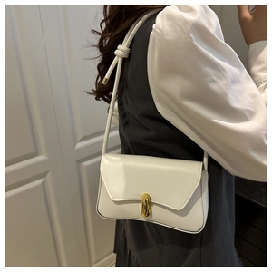 Minimalist white leather shoulder bag with a gold metal twist lock and knot shoulder strap