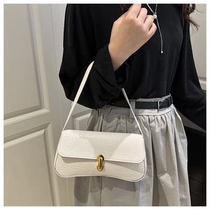 Détail du sac baguette en cuir gaufré crocodile blanc avec un fermoir ovale en métal doré