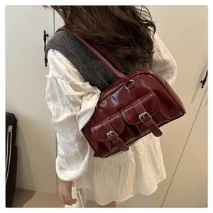 Detail of burgundy PU leather Boston bag with silver buckles and large capacity shoulder straps