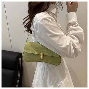 Détail du sac à bandoulière vert clair à motif crocodile avec boucle en métal doré