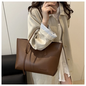 Detail of the large brown matte leather tote bag with a Fashion embossed label