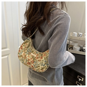 Detail shot of vintage floral hobo bag with jacquard fabric and metal logo plaque