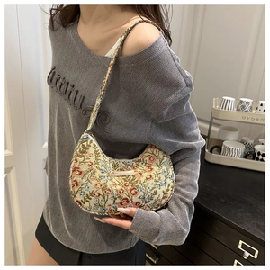 Detail of vintage tapestry hobo bag featuring floral embroidery and crescent shape