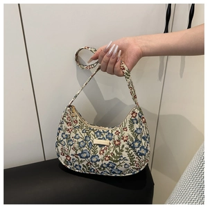 Detail of vintage floral tapestry hobo bag with colorful jacquard textile patterns