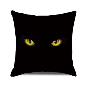 Nahaufnahme gelber Katzenaugen auf schwarzem Halloween-Kissenbezug aus festem Stoff