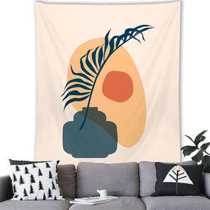 Abstract palm leaf wall tapestry hanging above a grey sofa in a modern living room