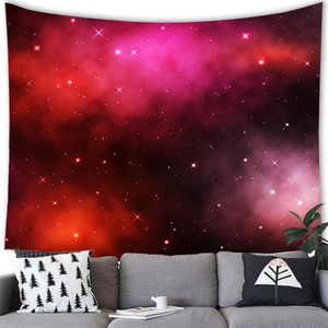 Nebula tapestry hanging over a grey sofa with decorative pillows and green plants