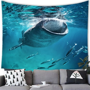 Detail of whale shark tapestry showing vibrant marine life above a modern grey sofa