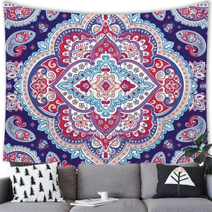 Bohemian mandala tapestry with red and blue patterns hanging above a modern sofa