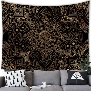 Detail of bohemian mandala wall tapestry with gold paisley patterns on black fabric