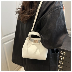 Detail of white mini bucket bag with lychee texture leather and gold twist lock clasp