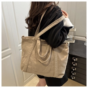 Detail of beige corduroy tote bag showing large capacity and shoulder strap texture