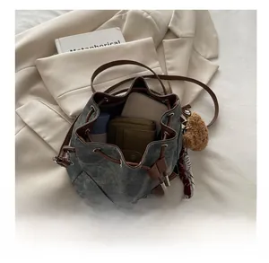 Top view of spacious denim bucket bag interior showing capacity with wallet and phone