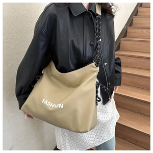 Detail der Hobo-Tasche mit Fashion-Aufdruck und schwarz-weiß gestreiftem Seilschultergurt