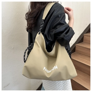 Close-up of khaki tote bag with drawstring detail and white FASHION lettering