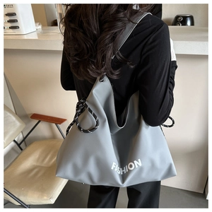 Detail view of large grey tote bag with white fashion text and rope drawstring detail