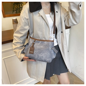 Detail of vintage blue canvas bag with brown leather trim and FASHION logo tag