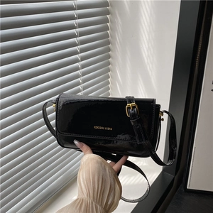 Glossy black patent leather baguette shoulder bag with gold buckle and brand logo
