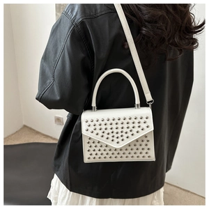 White leather square bag with silver metal rivets worn by model in black leather jacket