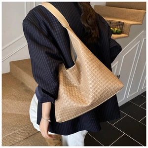Detail of khaki woven hobo bag showing intricate leather texture on shoulder