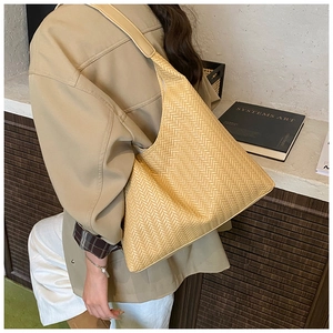 Detail of woven hobo tote bag in beige faux leather showing large capacity and strap