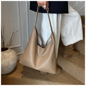 Detail of khaki woven hobo bag with grid pattern texture and large capacity shoulder strap