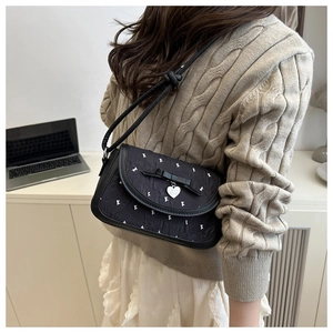 Detailansicht schwarze Schleifen-Tasche mit K-Print und Herzanhänger-Details
