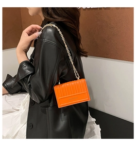 Borsa a tracolla arancione con cuciture verticali mostrata di lato su una modella