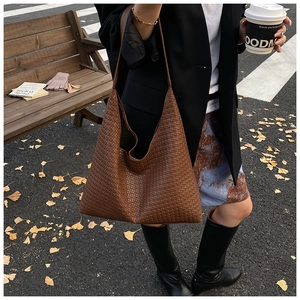 Detail of dark brown woven texture on large tote bag with autumn city street scenery