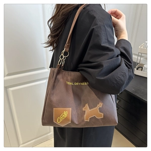 Dettaglio della borsa tote marrone scuro con stampa Tidal Dryness e toppa ricamata cane