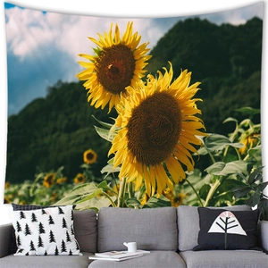 Detailed close-up of sunflower tapestry hung above a sofa, showing high-definition print
