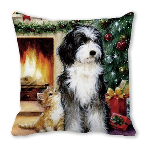 Détail du coussin de Noël montrant un chien et un chat près d'une cheminée