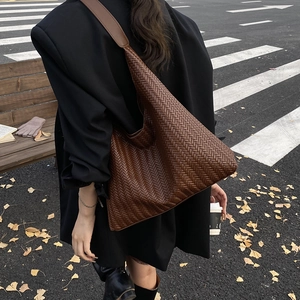 Retro dark brown woven leather hobo bag for women in an autumnal street setting