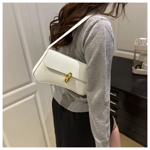Close-up of white leather baguette bag with a gold oval metal buckle and lychee texture