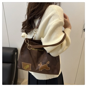 Borsa a spalla marrone con stampa Tidal Dryness e patch a cucciolo indossata da modella