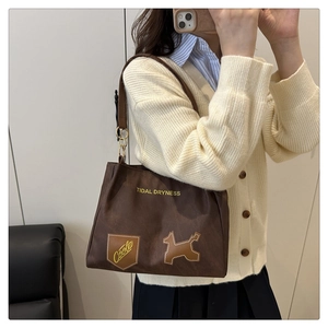 Dettagli della borsa tote in tela marrone scuro con ricami e manici in pelle regolabili