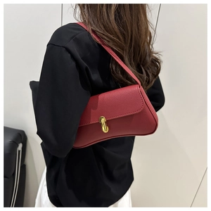 Detail view of red grainy leather crescent shoulder bag with golden rectangular twist lock
