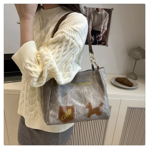 Dettaglio della borsa tote grigia vintage con scritte Tidal Dryness e toppa decorativa
