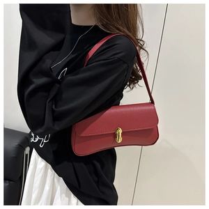 Detailed view of dark red crescent shoulder bag with pebbled leather and gold buckle