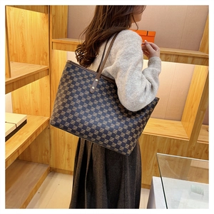 Detail of large tote bag with brown checkered pattern and sleek shoulder straps for women